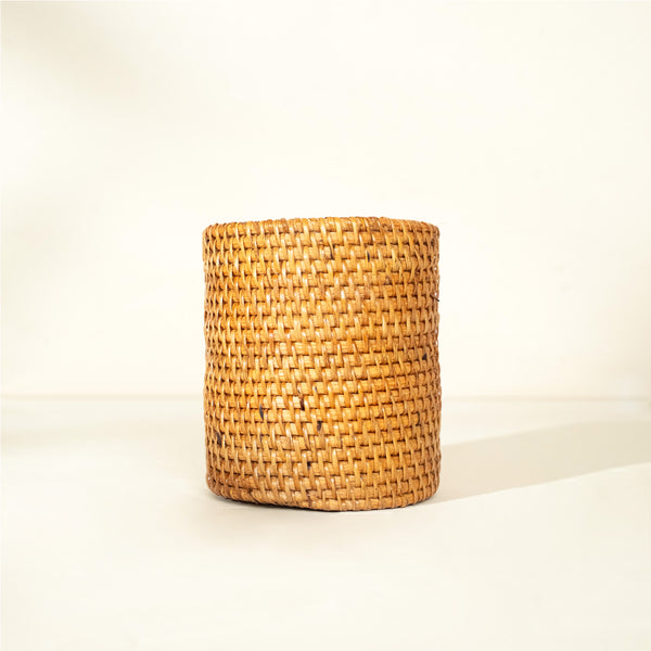 Natural handwoven rattan plant pot with cylindrical shape on a neutral background