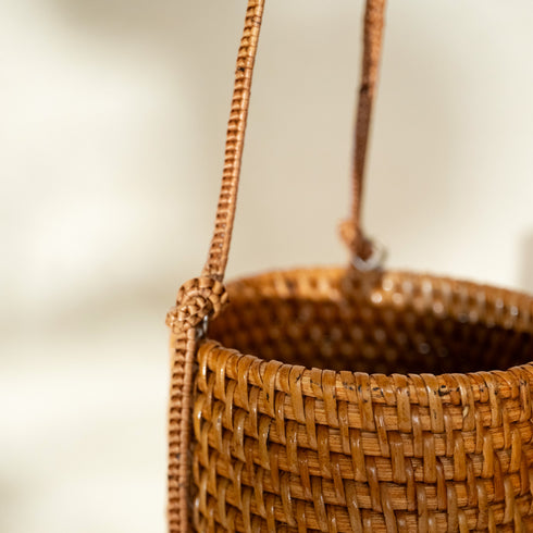Close up of honey rattan hanging planter showing natural woven pattern and finish