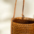 Close up of honey rattan hanging planter showing natural woven pattern and finish