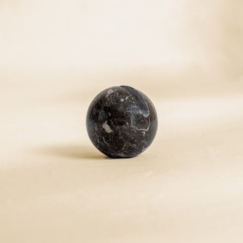Black marble ball on a beige background cable organisation