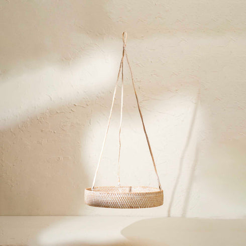 Woven basket hanging against a plain wall
