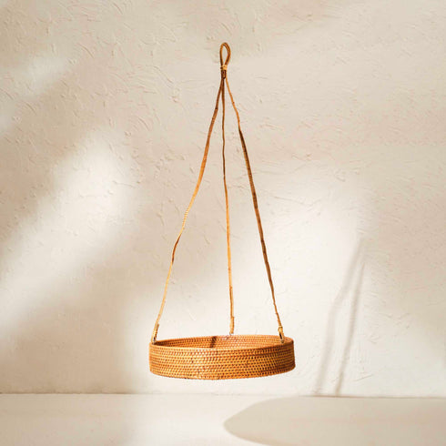 Woven hanging basket with a rope handle on a light background