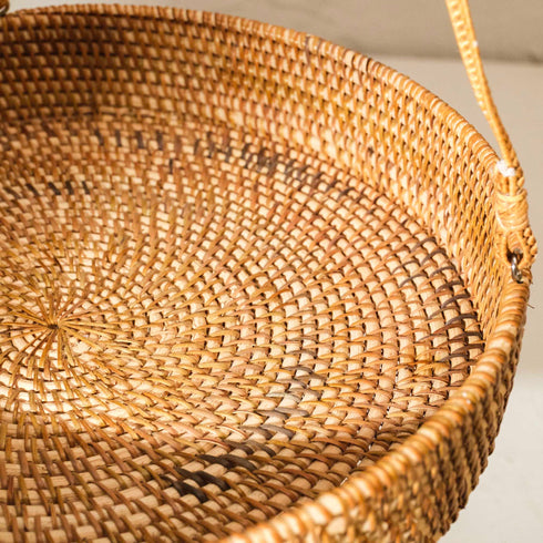 Close-up of a woven basket with a handle on a light background