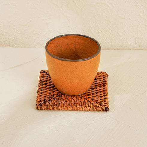 A Ceramic Cup with Square Rattan Coaster Underneath