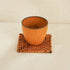 A Ceramic Cup with Square Rattan Coaster Underneath