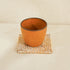 A Brown Ceramic Cup with White Rattan Square Coaster