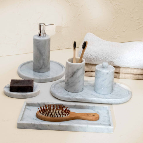 Bathroom set with marble tray, soap dispenser, toothbrush holder, and hairbrush on a neutral background