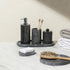 Black marble bathroom accessories set on counter