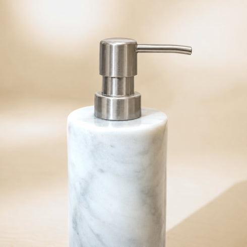 Close-up of Carrara marble soap dispenser with brushed steel pump