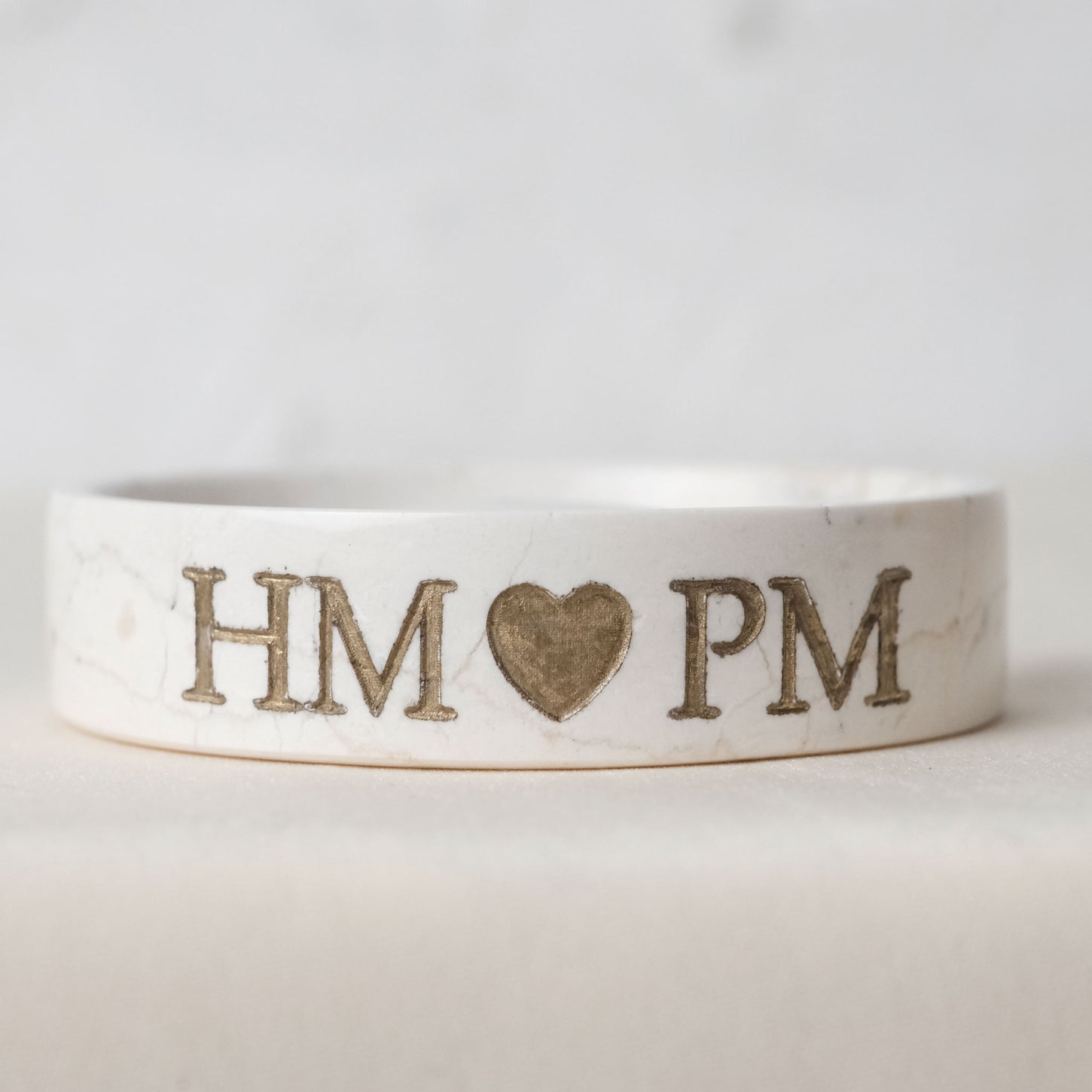 A White Marble Trinket with letter HM and PM written on it